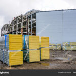 sandwich wall panels in piles, ready to be mounted on the wall of the factory housing